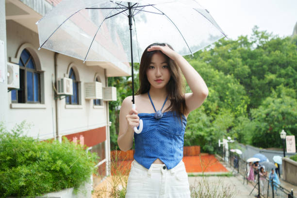 Young Asian female tourist holding umbrella in hand