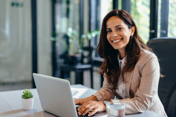 istock Professional woman at desk using laptop and sitting in modern office. 2169192294