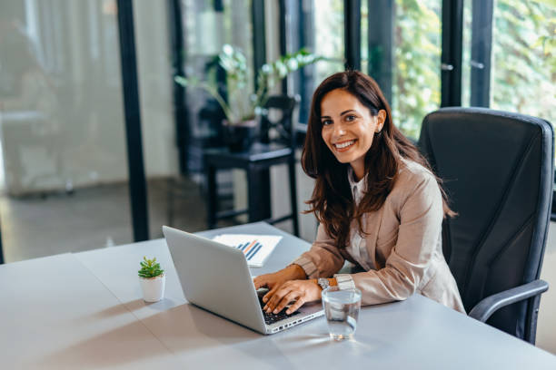 istock Professional woman at desk using laptop and sitting in modern office. 2169192317
