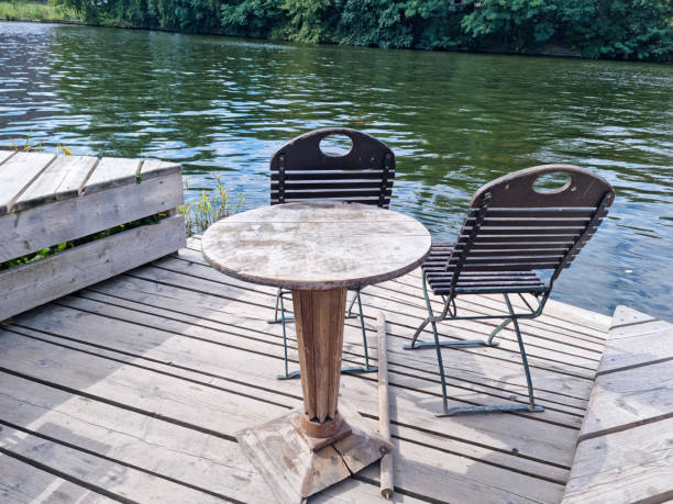 istock Wooden table with chairs outside at lake 2169193870