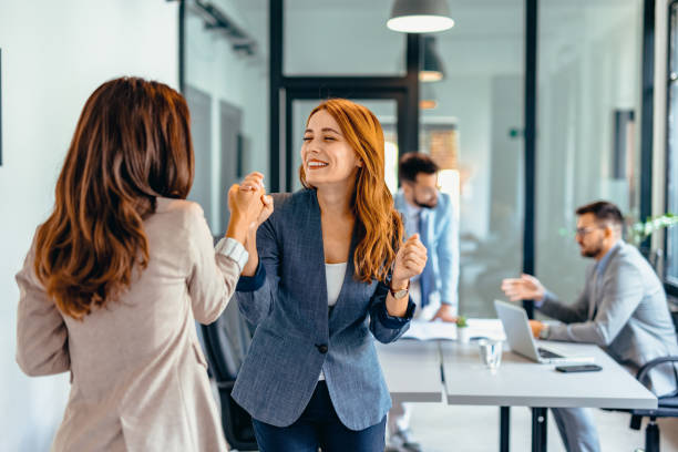 istock Two professional women celebrating success in a modern office space. 2169194020