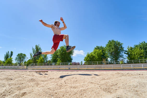 athlete performing a long jump during a training at stadium. championship concept