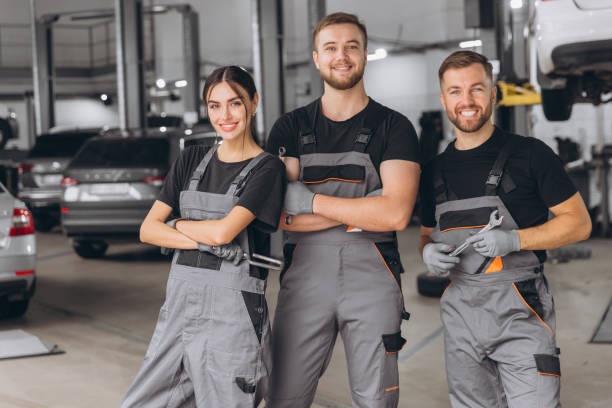 istock Group of three car service technician men and woman talking at workplace, people working together at vehicle repair garage service shop, check and repair customer car at automobile service center. 2169197301