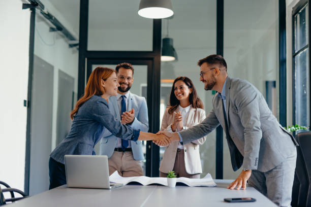 istock Business meeting with handshake and blueprints on table 2169197462