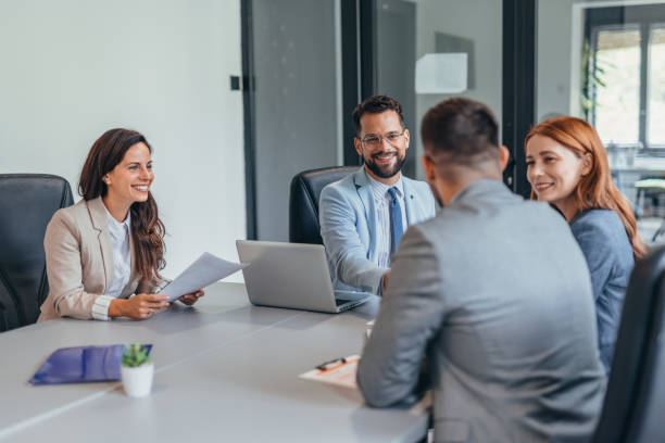 istock Four business professionals discussing in a modern office setting. 2169204614