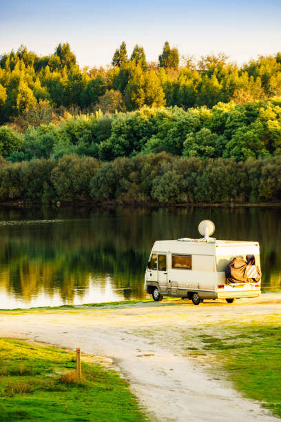 istock Caravan camping on lake shore with satellite dish on roof 2169204998