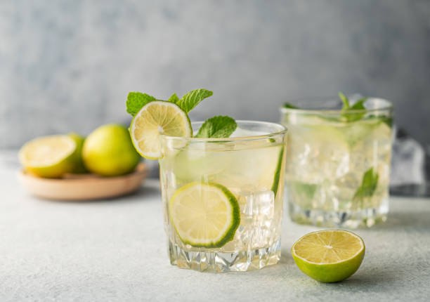 istock Two glasses mojito cocktail with lime, mint and ice on a light background. Trendy summer refreshing lemonade drink concept 2169206271