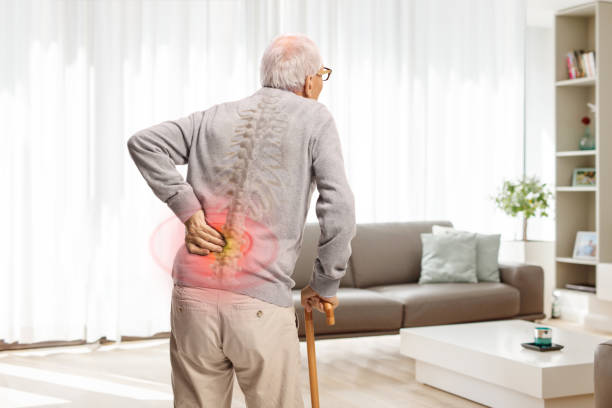 istock Older man with a cane holding his painful back 2169206319