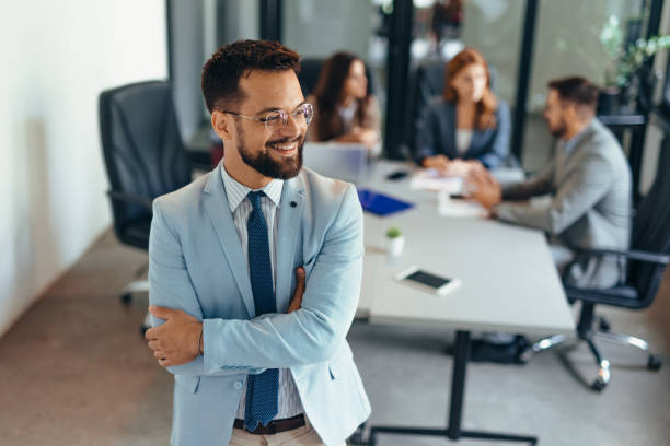istock Successful businessman in modern office looking away while standing 2169207574
