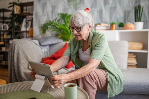 istock Elderly woman browsing on tablet while enjoying a drink 2169209234