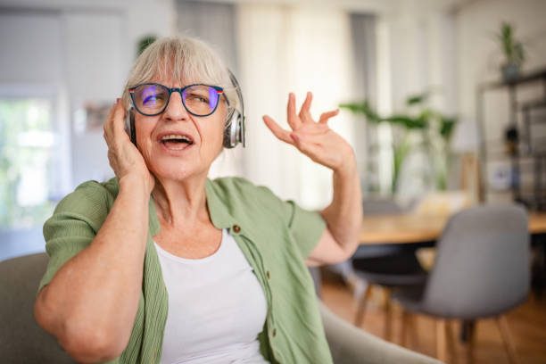 istock Elderly woman dancing, headphones on, cheerful expression. 2169209616