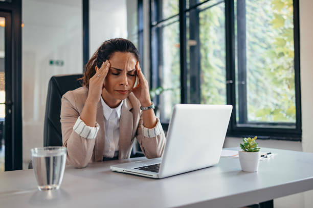 istock Professional woman stressed while working at her desk in office 2169210398