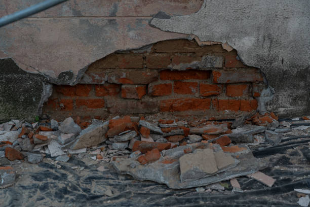 istock Old, fallen-off plaster from a brick building. Red brick behind the plaster 2169211102