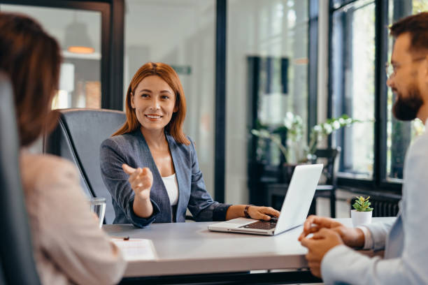 Three professionals in a discussion at an office meeting setting.