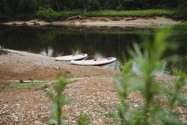 istock Experience a tranquil riverside view with paddleboards on the peaceful shore, surrounded by nature and calm waters, ideal for outdoor fun and relaxation in summer 2169214880