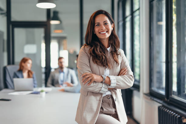 istock Smiling businesswoman standing confidently in modern office space. 2169215326