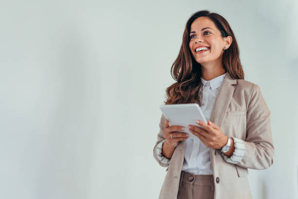 Business woman holding a tablet in a modern office setting.