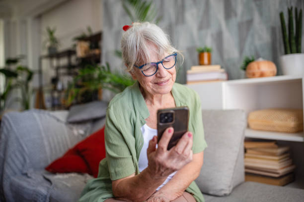 istock Senior woman using phone in comfortable living room. 2169215855