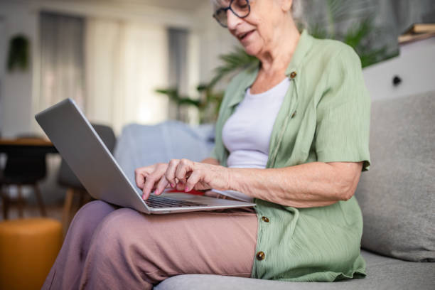 istock Woman on sofa using laptop in a green cardigan 2169219000