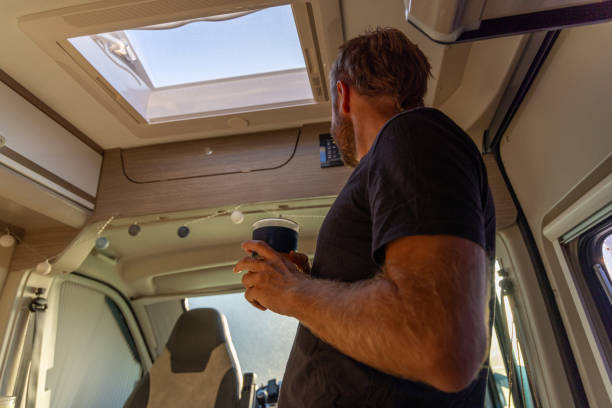 istock Man Enjoying Morning Coffee in Camper Van 2169219067