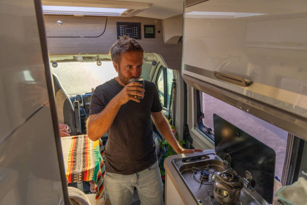 istock Man Enjoying a Hot Drink in a Camper Van Kitchen 2169219235
