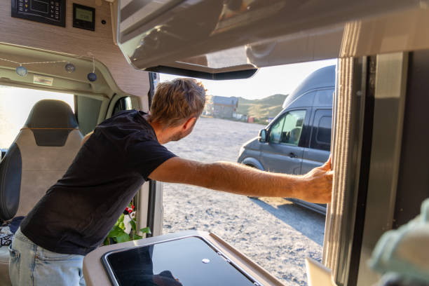 istock Man Opening Camper Van Door at Sunrise 2169219400