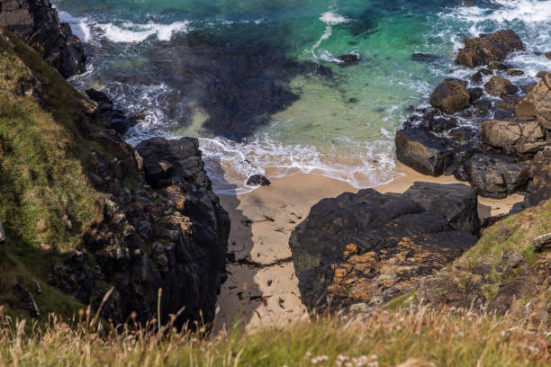 A high angle view of a hidden cove on the Cornish coast, on a sunny day
