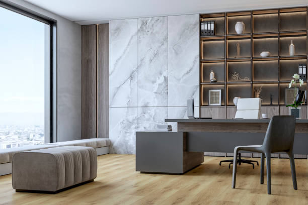 Side view of a modern home office with minimalistic design with a desk, decoration, ergonomic chair, soft bench and windows