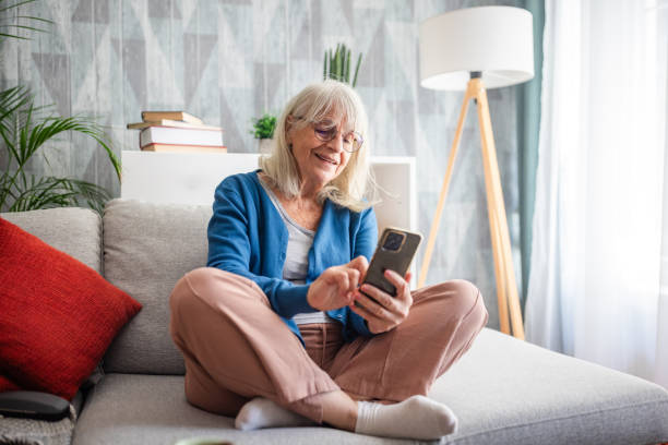 istock Person seated on sofa using a smartphone at home. 2169221531