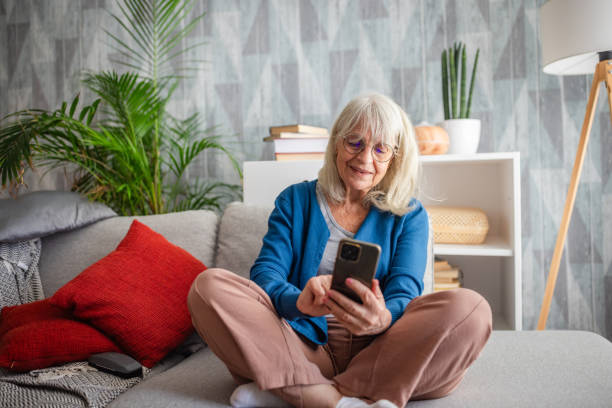 istock Senior woman checking her smartphone while seated 2169222168