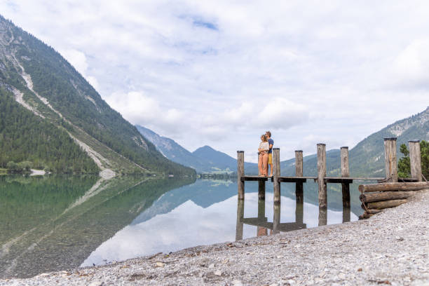 istock Couple Exploring Wooden Dock by Mountain Lake 2169223951