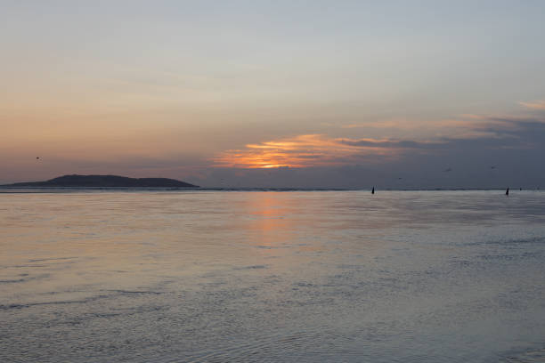 A view from Malahide Beach at low tide as the sun rises in the distance