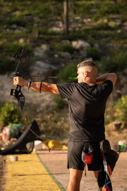 istock A man is holding a bow and arrow and is about to shoot it 2169225286