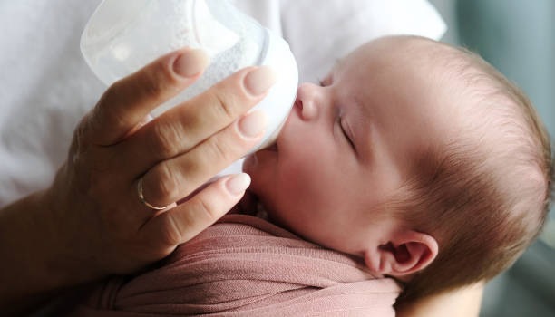 istock mother feeding her newborn baby formula from a bottle 2169235896