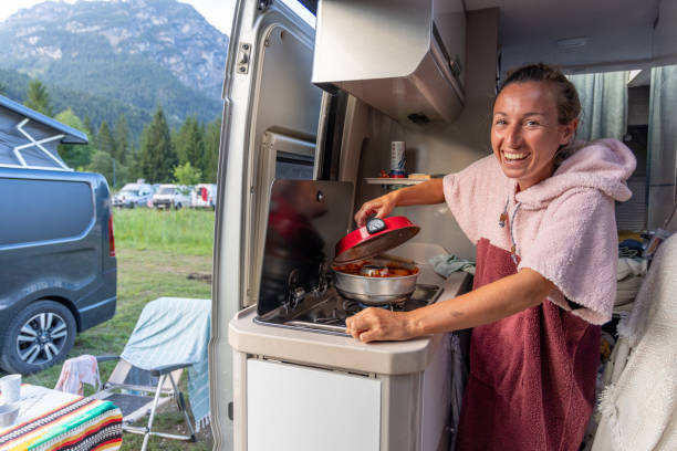 istock Woman Cooking in Camper Van Kitchen at Mountain Campsite 2169238155