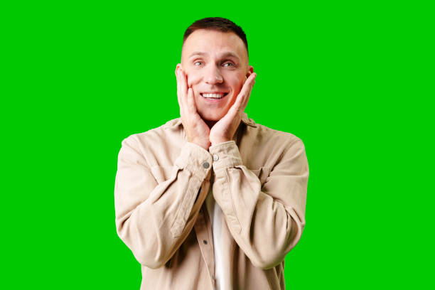 istock Cheerful Young Man Posing With Outstretched Hands Against a Bright Green Background 2169239405