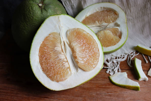 istock Pomelo fruit cut in half on wooden table. 2169241422