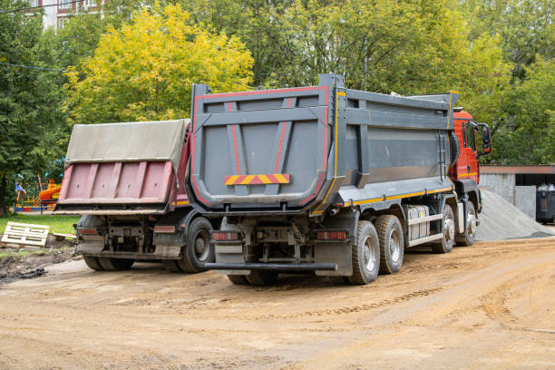 istock Two large dump trucks are parked next to each other on a dirt road 2169246874