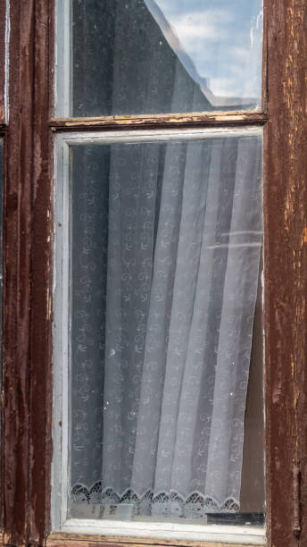 istock Old brown wooden window and curtains behind it 2169253370