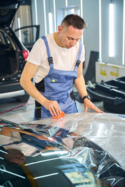 istock Master glues the protective film on the car 2169258135