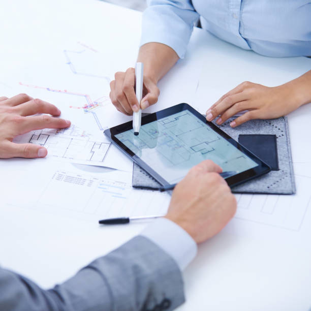 istock Tablet, blueprint screen or hands of people in meeting for planning or engineering project. Architecture strategy, teamwork or designers speaking of digital app, development or floor plan closeup 2169258169