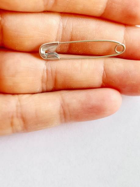 istock One metal safety pin in hand with white background 2169261794