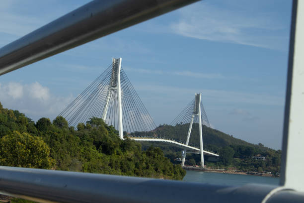 istock Jembatan Barelang or Barelang Bridge at  Batam Island, Indonesia, a bridge that connects Batam Island and Rempang Island. Cable-Stayed Bridge on Clear Sunny Day with Blue Sky and Empty Road in View 2169263668