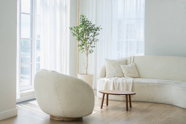 istock Stylish loft bedroom interior. Spacious design apartment with light walls large windows white couch sofa and armchair. Clean modern decoration with elegant furniture in minimalist Scandinavian style. 2169269332