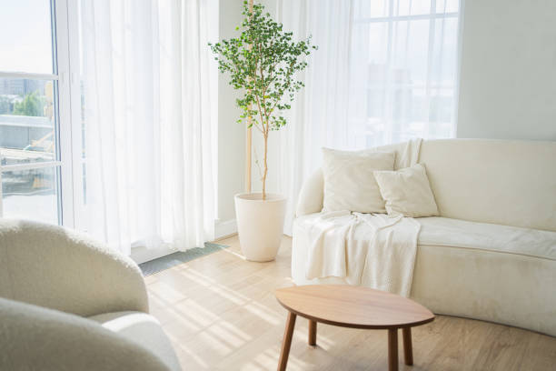 istock Stylish loft bedroom interior. Spacious design apartment with light walls large windows white couch sofa and armchair. Clean modern decoration with elegant furniture in minimalist Scandinavian style. 2169269335