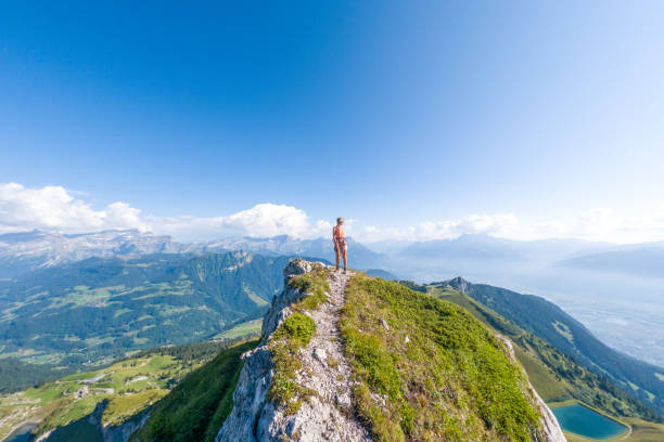 istock Woman Standing on Mountain Ridge with Panoramic Alpine View 2169271347