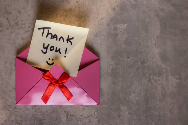 A pink envelope with a red ribbon and a note that says 
