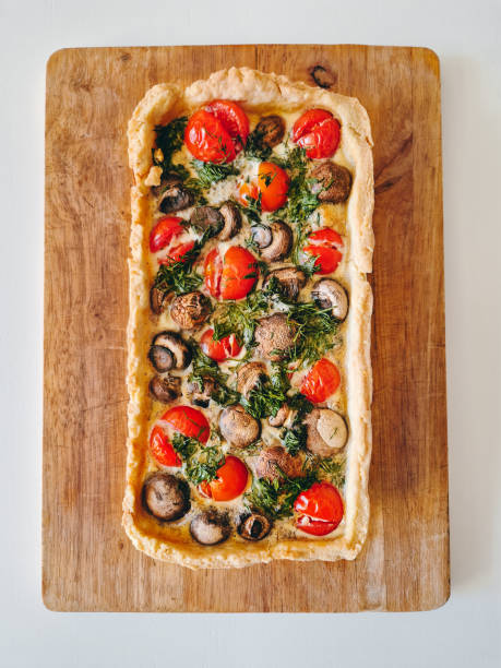 Top view fresh homemade pie with cherry tomatoes and mini champignons with herbs and eggs.