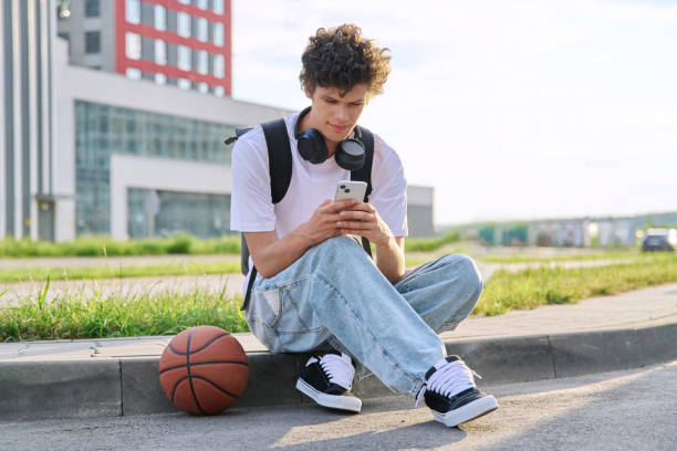 istock Young guy using smartphone, modern city street background 2169274598