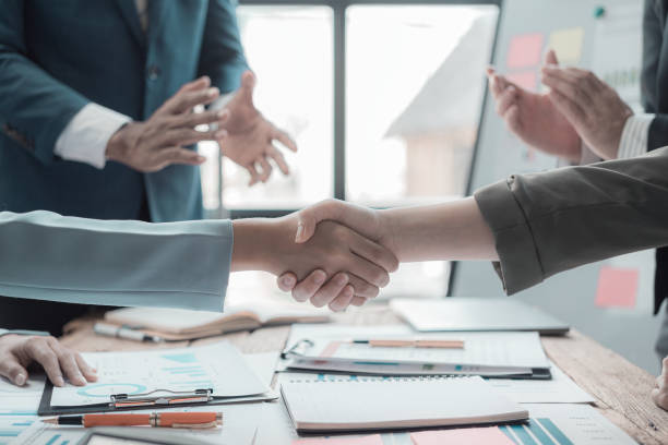 istock Businessmen shaking hands, greeting and working together, having documents with financial graphs and charts, brainstorming, close-up photo 2169274617